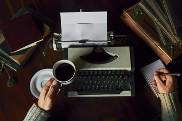 Young man writing on old typewriter.