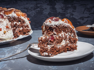 A large piece of homemade cake on a saucer shot close-up, in the background a cake