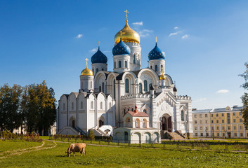 Nikolo-Ugreshsky monastery on a Sunny summer day with a cow grazing on a meadow, Dzerzhinsky,...