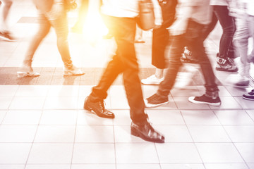 Abstract motion blur people walking on white tiled floor. They are hurry in rush hour.