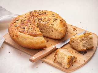 Homemade bread in cut and sliced chunks on a wooden kitchen board
