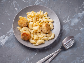 Breakfast of pasta and turkey meatballs in a gray plate and gray background