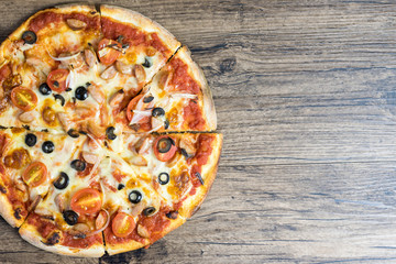 homemade vienna sausage pizza, Rustic pizza with mozzarella, olives, tomato and basil top view on the wood table.