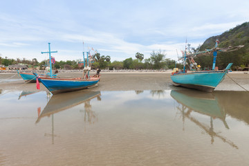 Fototapeta na wymiar Wooden fishing boat on the low tide beach.