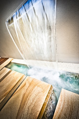 Waterfall on the wall and falling water in the wood