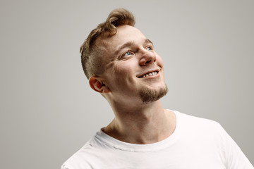 Fototapeta premium Happy business man standing, smiling isolated on gray studio background. Beautiful male half-length portrait. Young satisfy man. Human emotions, facial expression concept.