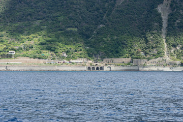 Italy, Cinque Terre, Monterosso, a large body of water with a mountain in the background