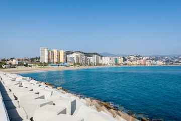 Dock of the port of Malaga with the beach in the background
