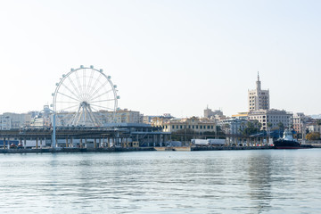 Port of Malaga with ferris wheel in background on a sunny day