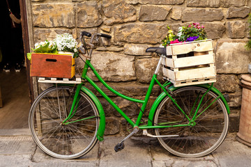 Fototapeta na wymiar Beautiful charming street landscape with an old bike with flowers in drawers