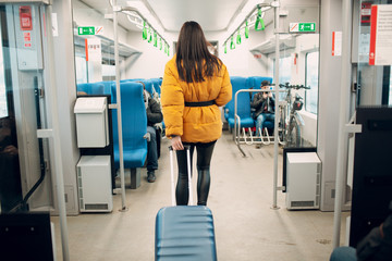 Young female walking and finding her seat in railway train.
