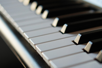 Electronic synthesizer piano keyboard in the sun's rays macro.