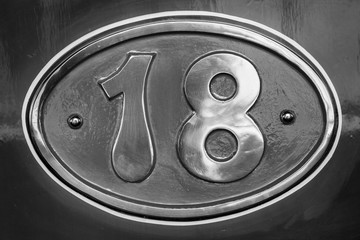 Vintage metal plate with number eighteen, detail of an old metal plate