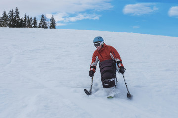 handicapped athlete goes downhill skiing, disabled skier and  disability snow sports,  handicapped...