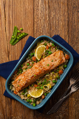 Asian dish. Fried salmon with rice and vegetables. Sprinkled with sesame seeds.