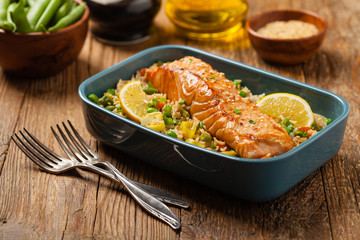 Asian dish. Fried salmon with rice and vegetables. Sprinkled with sesame seeds.