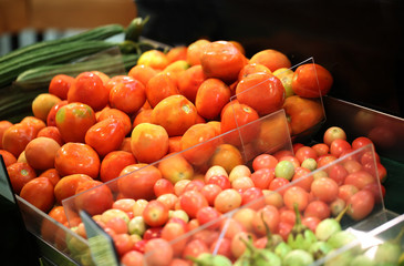 Group of fresh tomatoes for sale in supermarket.