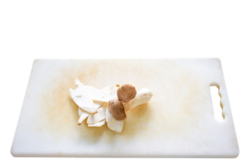 Sliced Eringii mushroom on the plastic chopping block close up.  Isolated on white background.