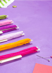 Multicolored threads for embroidery and pins on a bright background. Gift making sewing craft concept.