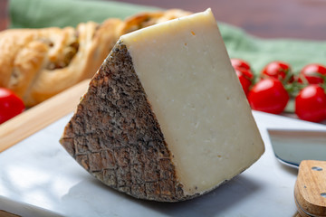 Italian cheese, piece of mature Tuscan Pecorino sheep cheese served with olive bread and tomatoes