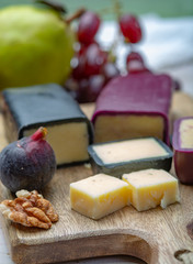 Mini black and dark red waxed cheddar cheeses made from West Country milk and and age-old methods in England