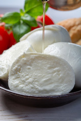 Balls and pieces of buffalo mozzarella, soft Italian scheese made from the milk of Italian Mediterranean buffalo