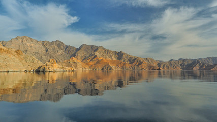 Fototapeta na wymiar Beautiful mountains reflected in the water. Fjords on the Musandam peninsula. Khasab. Oman