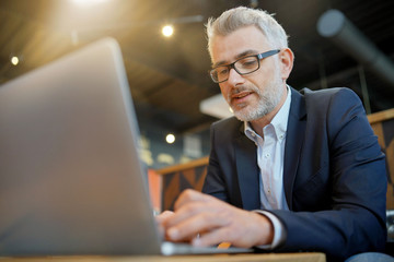 Businessman working on computer at airport restaurant