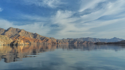 Beautiful mountains reflected in the water. Fjords on the Musandam peninsula. Khasab. Oman - obrazy, fototapety, plakaty