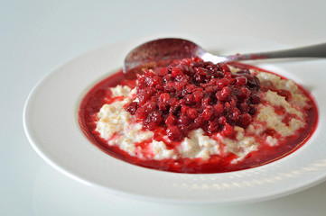Cowberry / lingonberry on top of an oatmeal porridge is a traditional Finnish breakfast or meal also for vegan and vegetarian diet