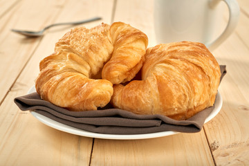 fresh baked croissants on wooden table