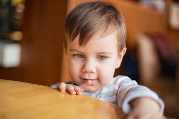 happy blonde mom and her little funny son rest in the cafe, drink tea and eat pies, have fun and have a nice family day together. selective focus, noise effect