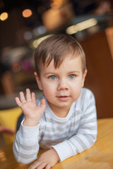 A little boy clapping his mother or his father in a palm, a photo from the first person. The boy gives his hand five to the friends opposite. Give me five