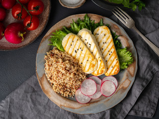 Halloumi, grilled cheese with quinoa, salad, radish. Balanced diet on  dark background, top view