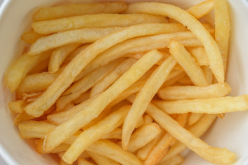 French fries in a paper cup. Selective focus and shallow depth of field.