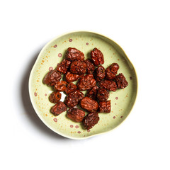 red dates on a plate isolated on white background.