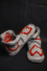knitted red slippers on a black background