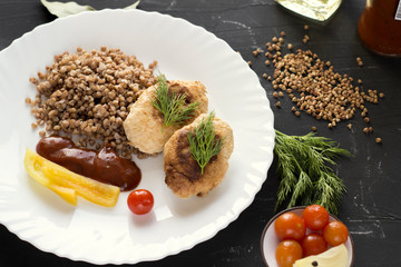 Chicken cutlets with buckwheat, herbs, ketchup and tomatoes