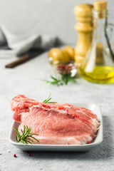 Raw pork chops, spices, herbs, olive oil. Selective focus, space for text.
