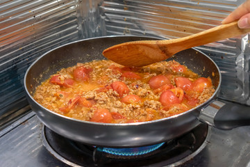 Cooking Nam Prik Ong Northern Thai Dipping Sauce on a Gas Stove.