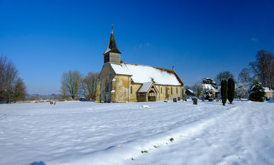 Fototapeta na wymiar Snowy view of the chapel of St Peter ad Vincula, Colemore, South Downs National Park, Hampshire, UK