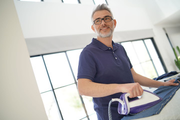 Man ironing shirt in stunning modern home