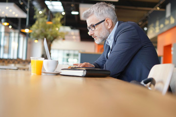 Businessman working in modern office cafeteria