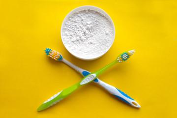 Tooth powder toothbrushes on a yellow background, symbol of clean and health and dental care