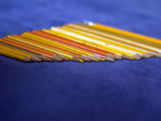 Color pencils on a purple plaid. Yellow pencils