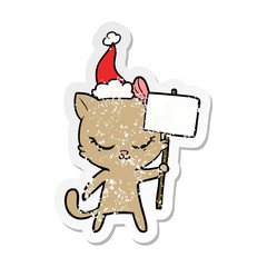 cute distressed sticker cartoon of a cat with sign wearing santa hat