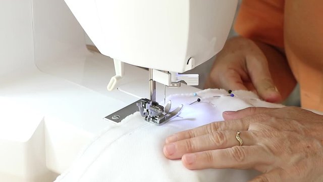 Costurando roupas feitas artesanalmente em seu ateli&ecirc;