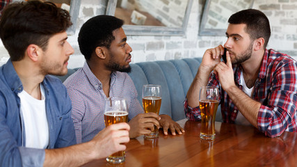 Man asking for silence, sitting in bar with friends