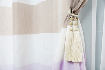 Beautiful draped window curtain with tieback in room, space for text