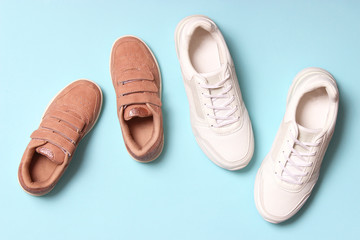  shoes for children and women's sneakers on a colored background top view. Footwear for children and adults.
